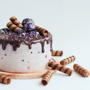 purple-glitter-blueberry-cake-with-chocolate-glaze-on-white-surface-copy-space